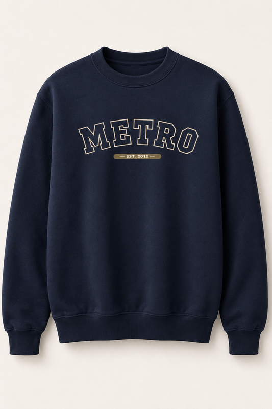 A navy blue crewneck sweatshirt with 'METRO EST. 2012' printed in arched varsity-style lettering on the chest, displayed against a light cream background.
